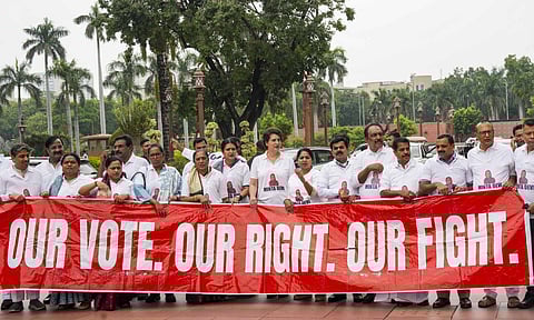 Congress MP Priyanka Gandhi Vadra and other INDIA bloc members seen wearing T-shirts featuring the name Minta Devi, a voter allegedly listed as 124 years old in the Election Commission's voter list, during their protest over the issues of 'poll fraud' and Special Intensive Revision of electoral rolls, at the Monsoon session of Parliament, in New Delhi, Tuesday, Aug. 12, 2025 (PTI) 