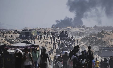 Palestinians carry sacks of flour unloaded from a humanitarian aid convoy on the outskirts of Beit Lahiya, northern Gaza Strip (AP)