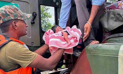 Indian Army personnel during evacuation of a woman and her 15 days old baby stuck in an inundated village. (PTI)