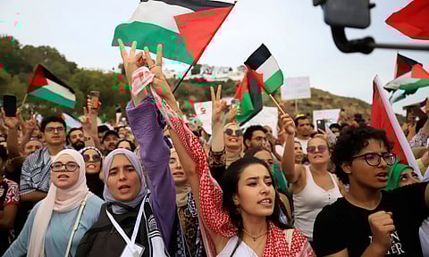 Tunisian people chant in support of the the Global Sumud Flotilla as it arrives at the port of Sidi Bou Saïd in Tunis (AP)