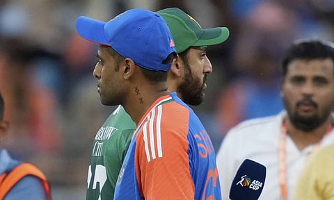 Pakistan's captain Salman Agha, rear, walks past India's captain Suryakumar Yadav after the coin toss ahead of the Asia Cup cricket match between India and Pakistan at Dubai International Cricket Stadium in Dubai, United Arab Emirates (PTI) 