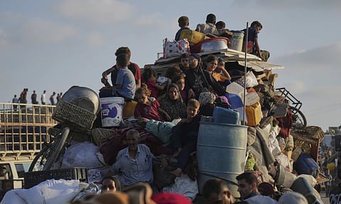 Displaced Palestinians flee northern Gaza by foot and in vehicles, carrying their belongings along the coastal road toward southern Gaza (AP)