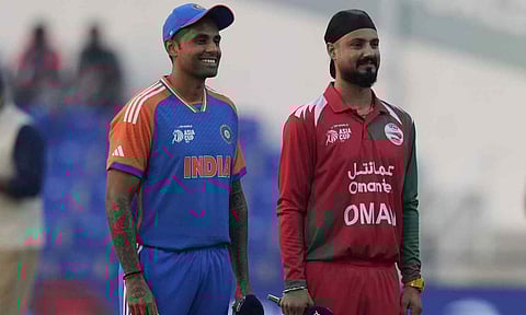 India's captain Suryakumar Yadav, left, and Oman's Captain Jatinder Singh stands to toss a coin during the Asia Cup cricket match between India and Oman at Zayed Cricket Stadium in Abu Dhabi, United Arab Emirates, Friday, Sept. 19, 2025. (PTI) 