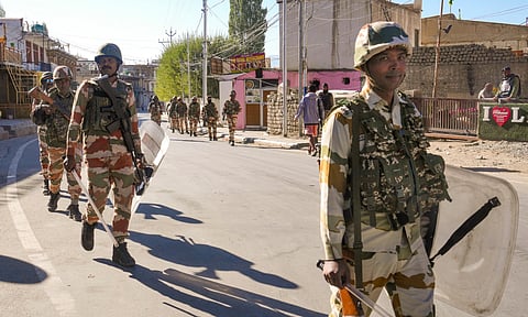 Security personnel patrol a street amid a curfew
