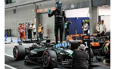  George Russell stands on his car as he celebrates getting pole position
