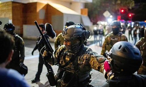 Police and Federal officers stand guard an area by the U.S. Immigration and Customs Enforcement facility in Portland, Ore (AP)