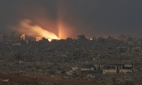 A fire erupts amid buildings destroyed during Israeli ground and air operations