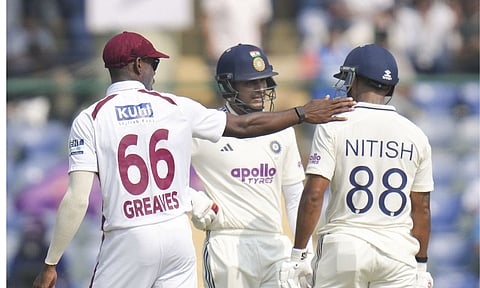 India's captain Shubman Gill, center, and Nitish Kumar Reddy, right, on day two of the second and final Test cricket match of a series between India and West Indies, at the Arun Jaitley Stadium, in New Delhi, Saturday, Oct. 11, 2025. West Indies' Justin Greaves is also seen. (PTI Photo/Shahbaz Khan)