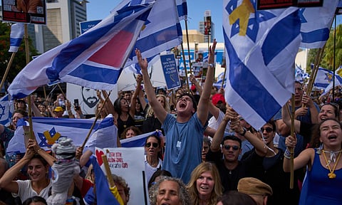 People react as they watch a live broadcast of Israeli hostages released from Hamas captivity in the Gaza Strip, at a plaza known as hostages square in Tel Aviv, Israel, Monday, Oct. 13, 2025 (AP) 