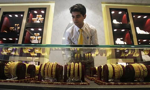 An employee displays gold ornaments at a jewellery showroom ahead of 'Dhanteras' festival, in Agartala (Photo: PTI)