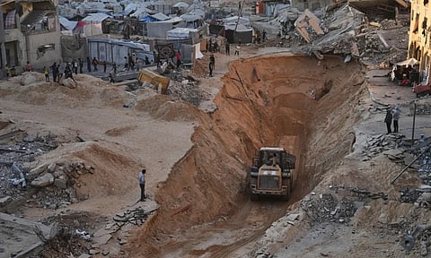 Palestinians watch members of the Hamas militant group searching for bodies of the hostages in Khan Younis, southern Gaza Strip (AP)