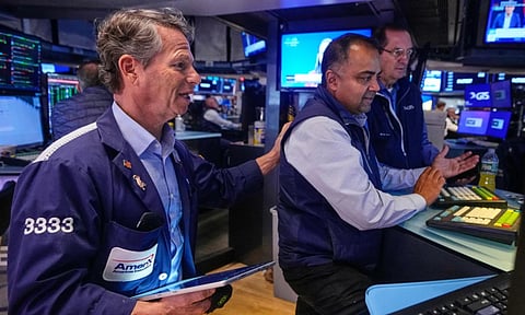 Trader Robert Charmak, left, and specialist Dilip Patel, center, work on the floor of the New York Stock Exchange (AP)