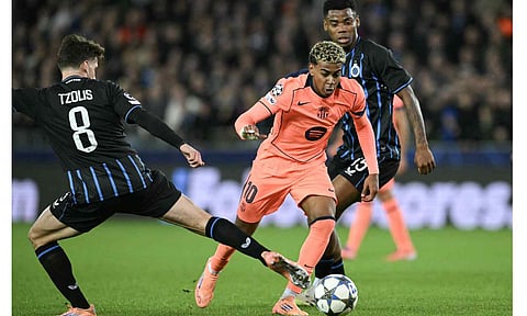 Lamine Yamal dribbles past Club Brugge players during a recent match 