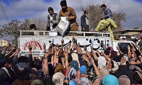 File Image of People jostle each other to buy subsidised sacks of wheat flour in Quetta, Pakistan (AP) 
