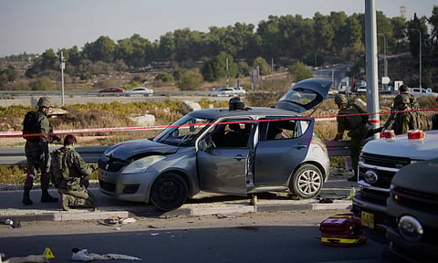 Members of Israeli security forces inspect the site of a ramming and stabbing attack near the West Bank Jewish settlement of Gush Etzion (AP)