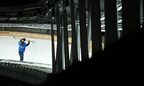 A man works on the track ahead of a three-day skeleton and bobsled World Cup stage and Olympic test event in Cortina D’Ampezzo. (Photo: AP)