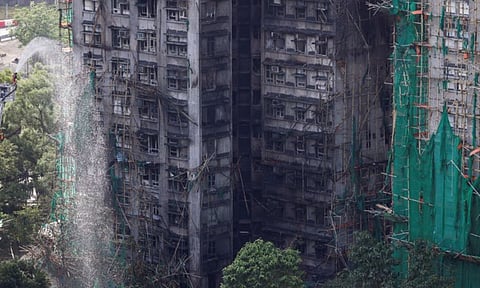 A firefighter works in front of the multiple charred buildings of Wang Fuk Court complex in Tai Po, Hong Kong, on November 28. Reuters