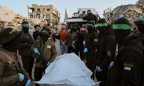 Masked Islamic Jihad and Hamas militants hand over a body bag believed to contain the remains of a deceased hostage to the Red Cross for transfer to Israeli authorities, in Beit Lahiya, in the northern Gaza Strip. (Photo: AP)