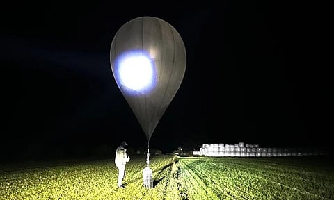 Officer inspects a balloon used to carry cigarettes into Lithuania, because Belarussian smugglers often use them to ferry the contraband into the European Union (AP)