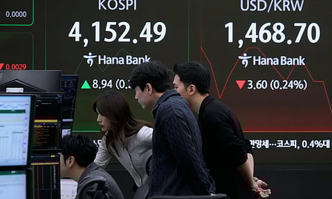 Currency traders watch monitors near a screen showing the Korea Composite Stock Price Index (KOSPI) and the foreign exchange rate between U.S. dollar and South Korean won, right, at the foreign exchange dealing room of the Hana Bank headquarters in Seoul, South Korea. (Photo: AP)