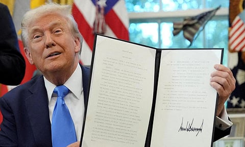 U.S. President Donald Trump displays a signed executive order on gold card visa in the Oval Office at the White House in Washington, D.C (Reuters)