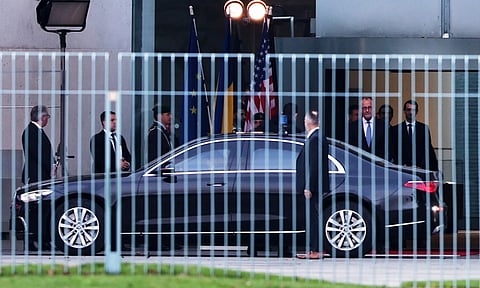German Chancellor Friedrich Merz, right, watches Ukraine's President Volodymyr Zelenskyy arriving at the chancellory in Berlin (AP)