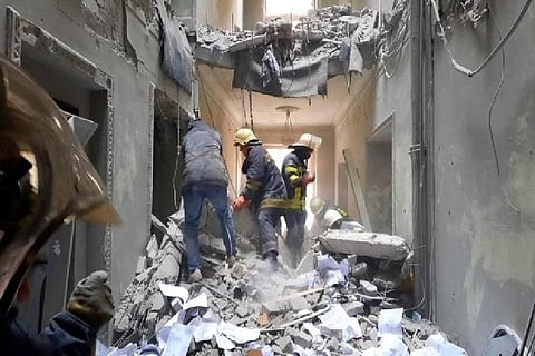 Rescuers are seen in a building, which city officials said was damaged by a missile