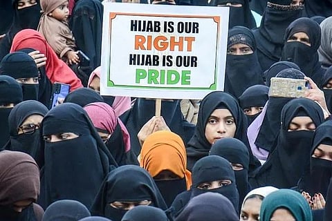 A woman holds a placard in Thane, Mumbai as a sign of protest against the hijab row.