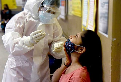 A health worker taking a swab sample from a women