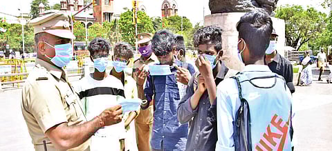 Triplicane Asst Commissioner Bhaskar distributes masks to visitors at Marina Beach on Saturday, and warned them of consequences if they didn?t take precautions.
