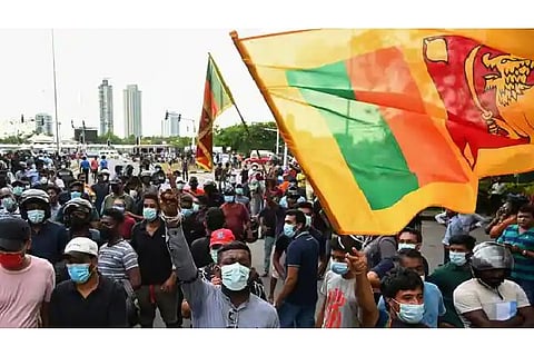 Demonstrators hold placards and shout slogans during a protest against the surge in prices and shortage of fuel and other essential commodities near the parliament building in Colombo