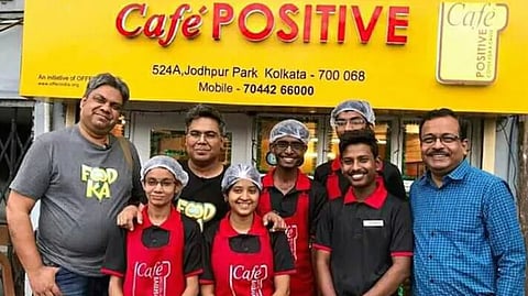 Staff pose in front of 'Cafe Positive'