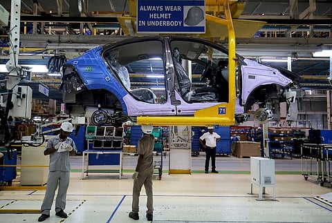 Workers assemble a Tata Tigor car inside the Tata Motors car plant