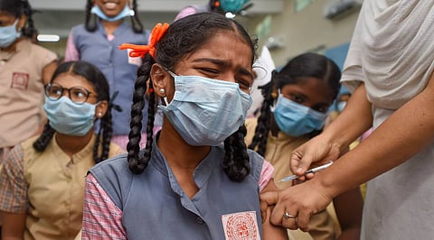 A healthcare worker administers a dose of a Covid-19 vaccine to a student, at a school in Chennai.
