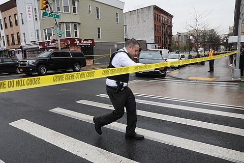 A police officer works near the scene of a shooting at a subway station in the Brooklyn borough of New York City