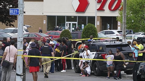 People gather outside a supermarket where several people were killed in a shooting