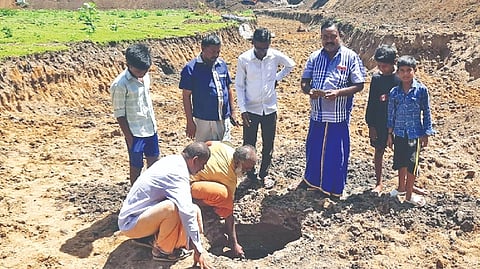 People inspecting a ring well being found in a temple tank in Thanjavur