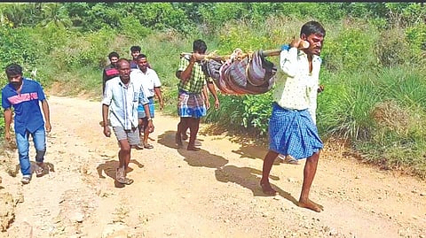 Nekkinamalai residents carrying the body of a man in dholi in the absence of a pucca road on Monday