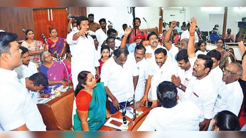 DMK councillors arguing with AIADMK members to vacate seats that were not allotted to them in Madurai Corporation on Wednesday