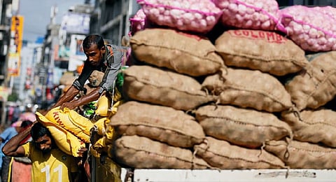 Labourers load food items into a delivery lorry near a main market in Colombo