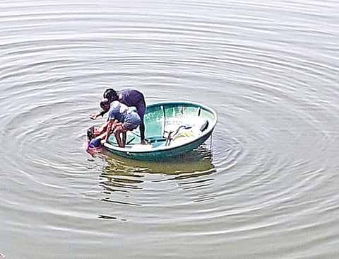 Two men rescuing the woman who jumped into Cauvery river