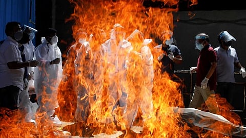 Relatives wearing personal protective equipment attend the funeral of a man who died from the coronavirus, at a crematorium in New Delhi
