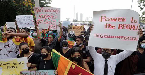 People hold placards as they demand Sri Lanka's President Gotabaya Rajapaksa to resign after his government lost its majority in the parliament