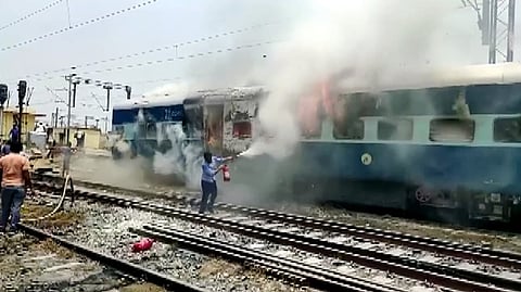 Protestors set a train ablaze during a protest against Agnipath scheme