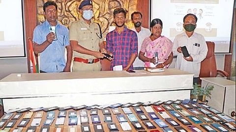 Superintendent of Police V Badrinarayan handing over recovered mobile phones to owners in Coimbatore on Friday