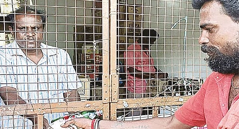 A customer receives Rs 10 after returning an empty liquor bottle at a Tasmac shop in Yercaud on Thursday