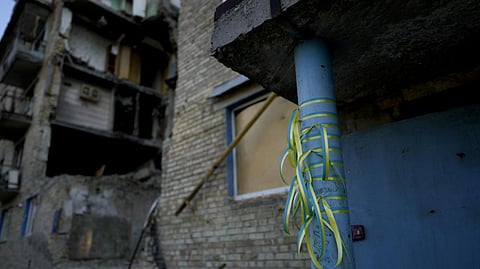 Ribbons in the colors of the Ukraine flag are tied to a building destroyed
