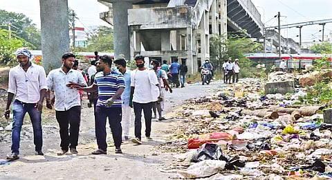 Residents and rail users cross the garbage-filled passageway near Pallavaram railway station