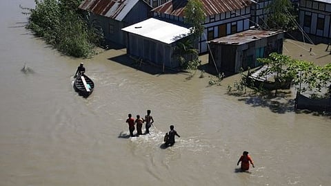 People wade through the water as they look for shelter