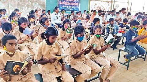Thanjavur CEO Sivakumar reading along with Thanjavur Corporation HSS students on Monday.
